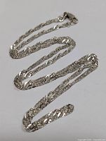 Photo showing the full length of the silver chain necklace laid out on a white surface.