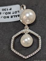 Close-up front view of the silver pendant showing a large pearl and a smaller pearl inside the hexagonal cubic zirconia frame.