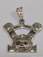 Front view showing detailed face motif and turquoise inlays