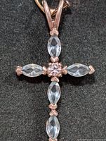 Close-up photo of silver pendant with four marquise-cut blue topaz stones and central round clear stone.