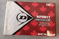 Red and white shipping box showing Dunlop logo and Canadian maple leaf pattern. Indicates 18 balls included.
