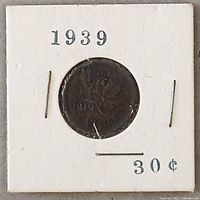 Front side of 1939 Canadian cent coin in white cardboard holder showing year, denomination, and maple leaf design.