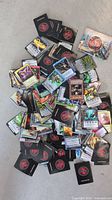 Chaotic trading cards scattered on a surface showing the front artwork and design of multiple cards.