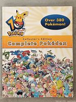 Front cover of the Pokedex book showing the 10th anniversary Pokemon logo and text stating Over 380 Pokemon included.