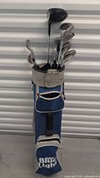 Full view of blue and white golf bag with golf clubs inside