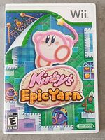 Front of the Wii game case for Kirby's Epic Yarn showing Kirby on a quilted fabric background with title.