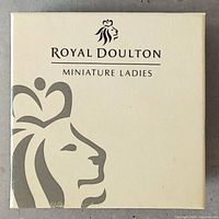Outer packaging box with Royal Doulton Miniature Ladies branding in cream color with a silver lion logo.