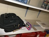 Black carry bag with pencils and sketching supplies on a shelf