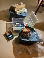 Three large totes on a basement floor, various Christmas decorations partly visible.