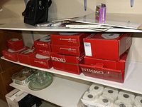 Shelf with multiple red Christmastime Nikko boxes in various sizes.