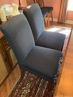 Pair of chairs side view showing upholstery and wood legs