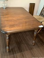 Top angled view of entire dining table showing wood surface, legs, and rounded corners.