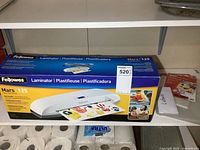 Fellowes Mars 125 laminator with its box and laminating pouches visible on shelf