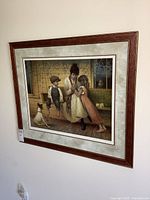 Photo of large framed print featuring a woman with two children and a dog on a porch, showing the full artwork and frame.