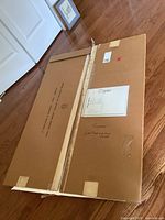 Photo of the back of a large mounted print packaging showing notes 'Signed Limited Edition Prints' and shipping info.