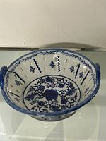 Photo showing full view of the bowl highlighting the blue and white floral pattern and cut-out design around the rim.