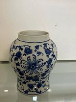 Front angle view of the blue and white porcelain jar showing detailed floral and vine patterns.