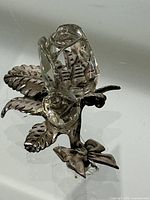 Front angle image of the standing rose figurine showing faceted glass flower, metal leaves, and bow base.
