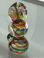 Front and side views of the multi-colored glass rabbit figurine showing detailed swirl patterns and clear glass structure.