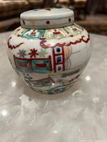 Side view of small Chinese Famille Rose baluster jar showing hand-painted traditional patterns in red, green, and yellow tones.