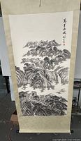 Full view of the scroll painting showing the mountainous landscape and Great Wall of China in ink and color with fabric mounting and wooden rods at top and bottom.