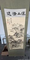 Full view of the hanging scroll painting showing mountain and river nature scene with calligraphy at top.