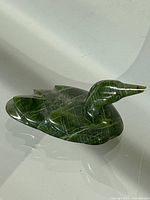 Side and angled view of the green marble loon figurine showing its detailed carving and polished surface with white veining pattern.