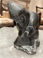 Front side angle of the Inuit soapstone carving showing detailed hood and posture.