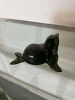 Soapstone seal carving from a side angle showing the smooth polished surface and thick body shape.