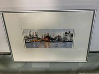 Full view of the framed watercolour painting showing an urban skyline reflected in water.