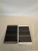 Front view of two Samsung tablets, one gold and one white, screens off.