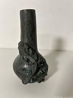 Full view bronze vase front showing relief design and neck