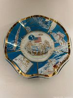 Front view of scalloped-edge Apollo 11 moon landing commemorative plate with blue, white and gold artwork