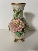 Full view of floral relief vase showing front flower detail and feet