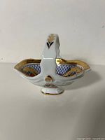 Profile view of handled candy dish showing overall form and gold accents