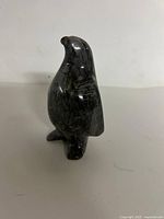 Front right view of polished dark grey stone penguin figurine