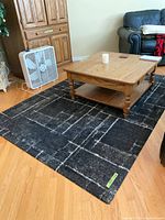 Full view of black/grey area rug under coffee table