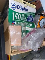 Box with Blue Dolphin 150-grit sanding sheets and other loose sheets