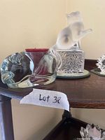 Shelf view showing glass cat candle holder, Lalique frosted cat figurine on mirror