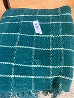 Grid-pattern teal throw folded on chair