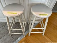 Two white wood counter stools front angle