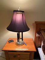 Full lamp lit on bedside table showing shade and base