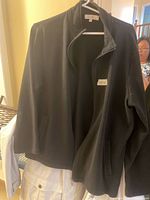 Full view of black fleece jacket on hanger