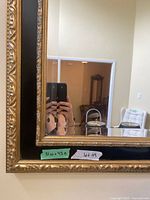 Close view of gold carved frame with black inset and glass