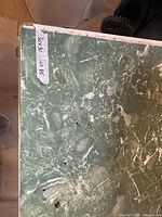 Top corner showing green marbled laminate surface and wear