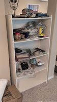 Front view showing entire white laminate bookcase with four shelves
