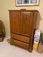 Front view of pine armoire showing two cabinet doors and two drawers