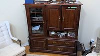 Front view of entertainment center showing glass display door, wooden doors, drawers