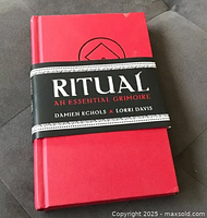 Front view of the hardcover book showing red cloth cover and belly band