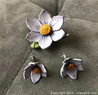 Brooch and earrings full view on grey fabric